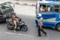A policeman approaching the biker on busy street in Sumatra.