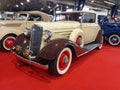 old vintage beige brown 1934 Chevrolet Chevy Master coupe cabriolet on red carpet. Classic car show