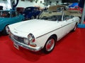 Old white 1975 Peugeot 404 cabriolet convertible on the red carpet. Exhibit hall. Classic car show