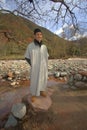 Berber boy standing on rock by river