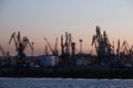 BERDYANSK - UKRAINE, SEPTEMBER 02, 2016: Many big cranes silhouette in the sea port