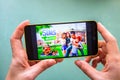 Berdyansk, Ukraine - March 4, 2019 - Close up of hand of person playing The Sims Mobile game apllication Royalty Free Stock Photo