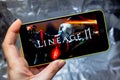 Berdyansk, Ukraine - March 16, 2019: Hands holding a smartphone with lineage 2 revolution game on display screen