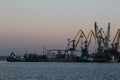 BERDYANSK - UKRAINE, SEPTEMBER 02, 2016: Many big cranes silhouette in the sea port