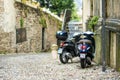 BERGAMO, ITALY - APRIL 2022: Motorcycles parked by narrow medieval street of Bergamo city northeast of Milan Royalty Free Stock Photo