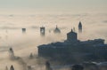 Bergamo, Italy. Drone aerial view of an amazing landscape of the fog rises from the plains and covers the old town Royalty Free Stock Photo