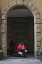 Bergamo, Italy - 24.6.2019: Red city scooter Vespa parked in round wall recess. Traditional, vintage Italian moped. Royalty Free Stock Photo