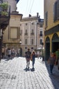 Bergamo / Italy/ September 9 2018 : A young couple stroll through the historic old town. The bright sunlight casts long shadows.