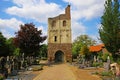 Idyllic dutch cemetery with old medieval roman tower, blue sky