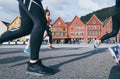 Bergen, Norway - August 2017: view over old Bryggen town houses with legs of jogging people on the foreground