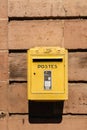 Old vintage French La Poste mailbox painted in yellow Royalty Free Stock Photo