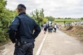 Croatian policeman looking at micrants crossing the Serbia Croatia border in Bapska, on the Balkans Route, during Refugees Crisis