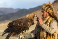 Berkutchi Eagle Hunter while hunting to the hare with a golden eagles on his arms in the mountains of Bayan-Olgii aimag. Royalty Free Stock Photo