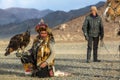 Berkutchi Eagle Hunter while hunting to the hare with a golden eagles on his arms in the mountains of Bayan-Olgii aimag. Royalty Free Stock Photo