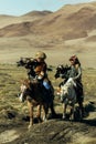 Berkutchi Kazakh Eagle Hunter while hunting to the hare with a golden eagles on his arms Royalty Free Stock Photo