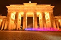 Berlin Brandenburg Gate at night time with color streak from passing vehicle showing contrast between motion vs permanence