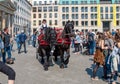 Brown horses, with a braided mane, harnessed to a carriage, near the Brandenburg Gate in Berlin, among the tourists