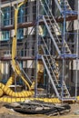 New construction on a construction site with scaffolding, hoses, ladders and various materials