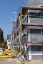 New construction on a construction site with scaffolding, hoses, ladders and various materials