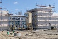 New construction on a construction site with scaffolding, hoses, ladders and various materials