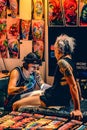 Annual convention of professional tattoo artists in Berlin. Jung pretty lady artist in black gloves makes a tattoo on the leg of a