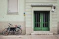 Entrance of a residential building in Berlin, green facade of a house and a bike