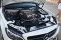 Berlin, Germany - August 20, 2022: Mercedes Benz C 63 S AMG engine closeup view with carbon details and lots female legs
