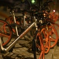 Parked rentable bikes in downtown Berlin, Germany. The bikes are standing in the light of a lantern at evening