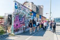 Undefined people walking near East side gallery at Berlin wall.