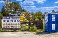 View to a jobsite with warning signs, digger and makeshift toilet