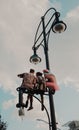 Berlin, Germany - 7/27/2019: Christopher street day in Berlin, young people siting on a light pole. Berlin pride Royalty Free Stock Photo