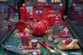 Ornate red painted teapot and crockery utensils with Christmas decorations at showcase of souvenir shop in Europe. Shop window