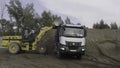 Berlin - Germany, december 6, 2022: Construction digger machine loading truck with sand. Scene. Heavy equipment for