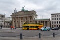 Berlin, Germany. February 19, 2019. A double-decker tourist bus drives along the road against the background of the Brandenburg