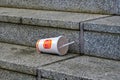 Carelessly discarded one-way drinking cup from a fast food chain on a staircase