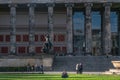 BERLIN, GERMANY - July 28, 2018: man sitting in front of the Altes Museum, its jonic columns and antique statues, and