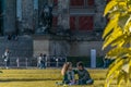 BERLIN, GERMANY - July 28, 2018: Passionate couple sitting in the grass and enjoying the sunlight at the Lustgarten a