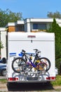 A white motorhome with a cycle carrier attached to the rear with two bicycles and a child`s bike