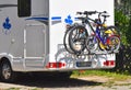 A white motorhome with a cycle carrier attached to the rear with two bicycles and a child`s bike