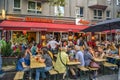 Fully occupied tables and chairs at a street festival. Guests eating and drinking in a restaurant in the center of Berlin