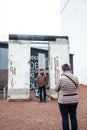 Tourists looking at a piece of the Berlin Wall at the entrance of the BlackBox Cold War Museum Royalty Free Stock Photo