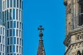 Pointed tower with cross of the memorial church in front of a blue sky next to a modern high-rise building with strict rectangular Royalty Free Stock Photo