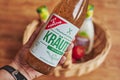 Bottle with salad dressing and German lettering held in one hand