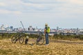 Man and boy resting beside their bicycles on the `Teufelsberg` devil hill, looking at the skyline of Berlin