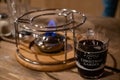 Berlin / Germany - 12 13 2018: Transparent glass mug with mulled wine inside near burner for traditional French cheese fondue. Royalty Free Stock Photo