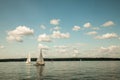 Berlin,Germany, 03.08.2019 .two beautiful sailing yachts on a blue lake and a green shore in the distance on a sunny day under a b Royalty Free Stock Photo