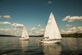 Berlin,Germany, 03.08.2019 .two beautiful sailing yachts on a blue lake and a green shore in the distance on a sunny day under a b Royalty Free Stock Photo