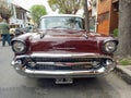 Old red 1957 Chevrolet Chevy Bel Air sport sedan two door parked in the street. Iconic classic car.