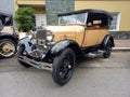 Old cream 1930s Ford Model A double phaeton convertible parked in the street. Classic car show.