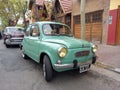 old green 1970s Fiat 600 sedan two door rear engined unibody parked in the street. Classic car show.